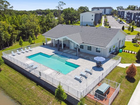 an aerial view of a house with a swimming pool and patio furniture